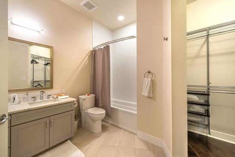 spacious bathroom with carrara quartz counters and grey cabinetry