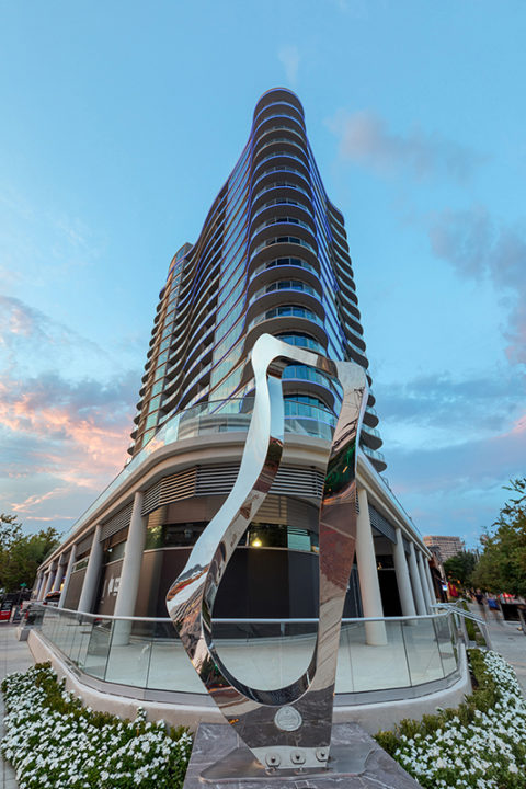 exterior of One Uptown at night with art sculpture
