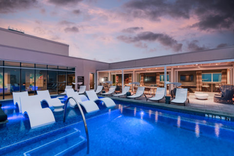 One Uptown Stunning rooftop pool with city views and lounge seating